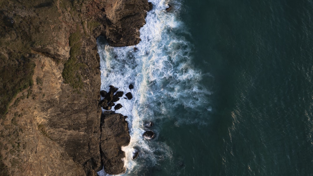 aerial photography of waves crashing on rocks
