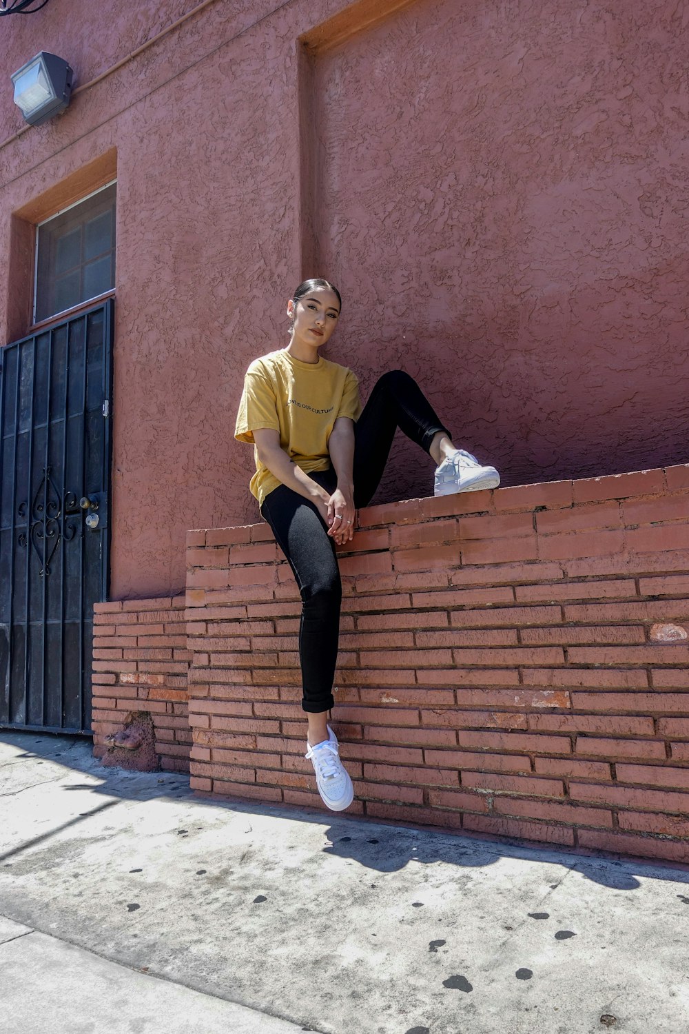 donna in camicia gialla che si siede sulla panchina di cemento