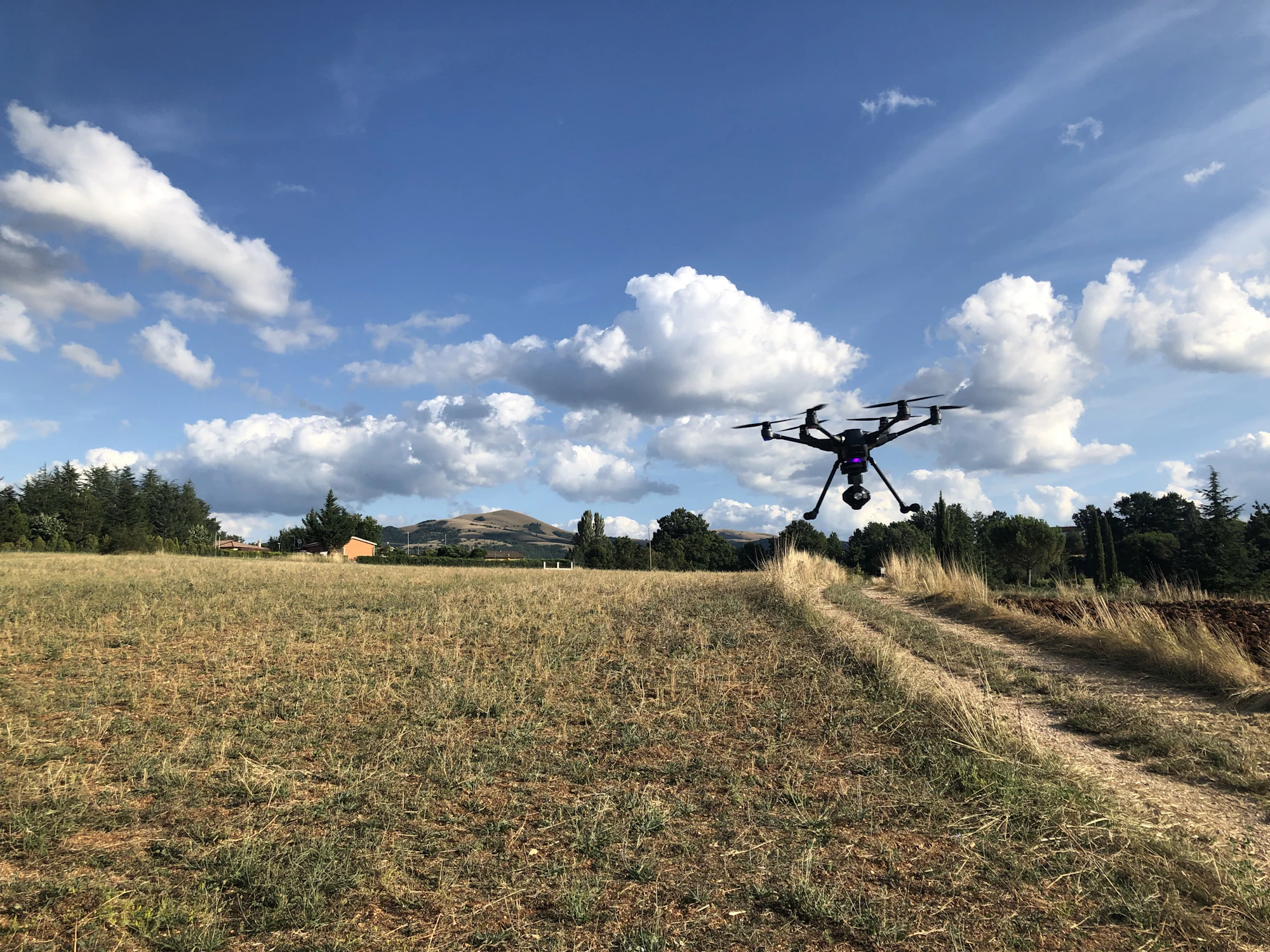 Survey drone in flight over open farmland during a mapping mission