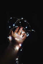 A small hand reaching out to touch a glowing nightlight shaped like a star.