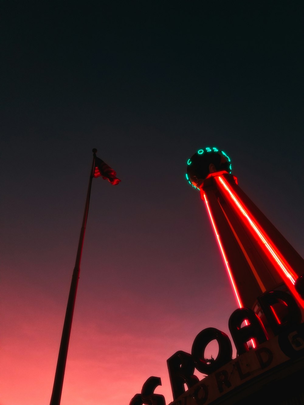 a red and green light shines on the top of a building