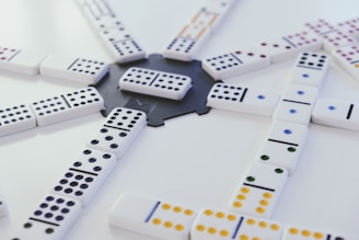 Illustration showing domino pieces in various game positions with mathematical symbols overlay.