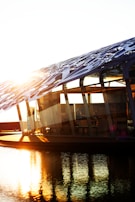 Sunlight reflecting off the glass facade of a high-end home nestled by the water.