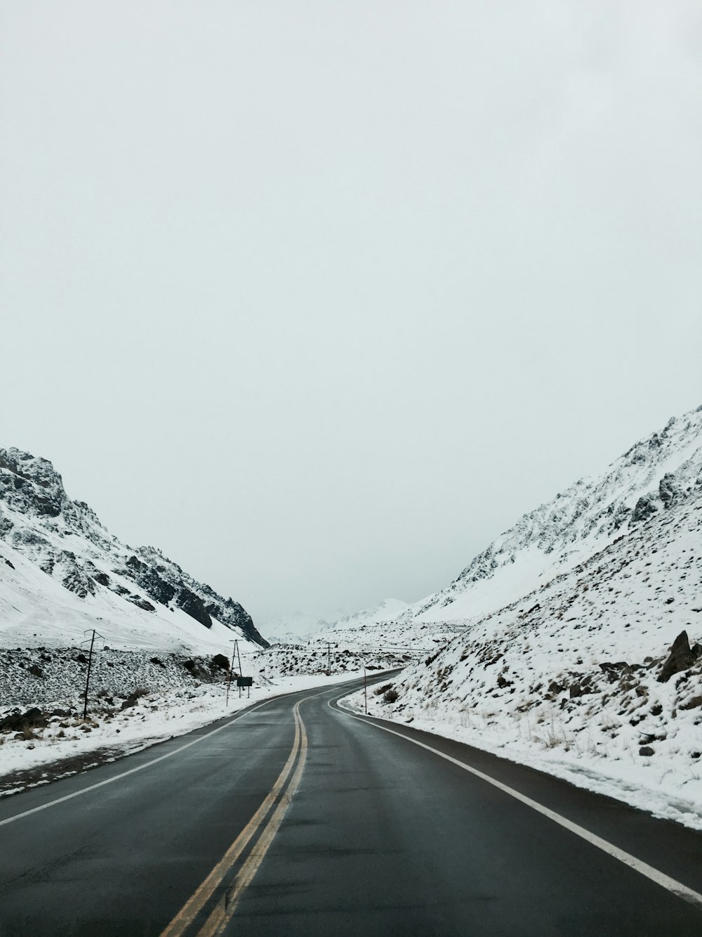 a snowy road with a mountain in the background