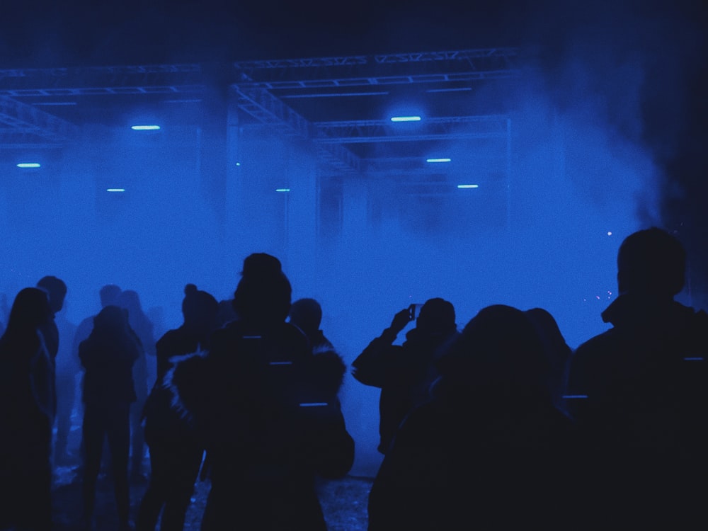 a group of people standing in front of a blue light