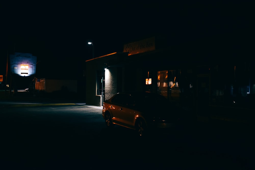 a car parked in front of a building at night