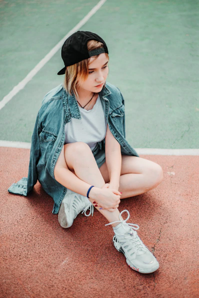 shallow focus photo of woman sitting on floor in blue denim jacket