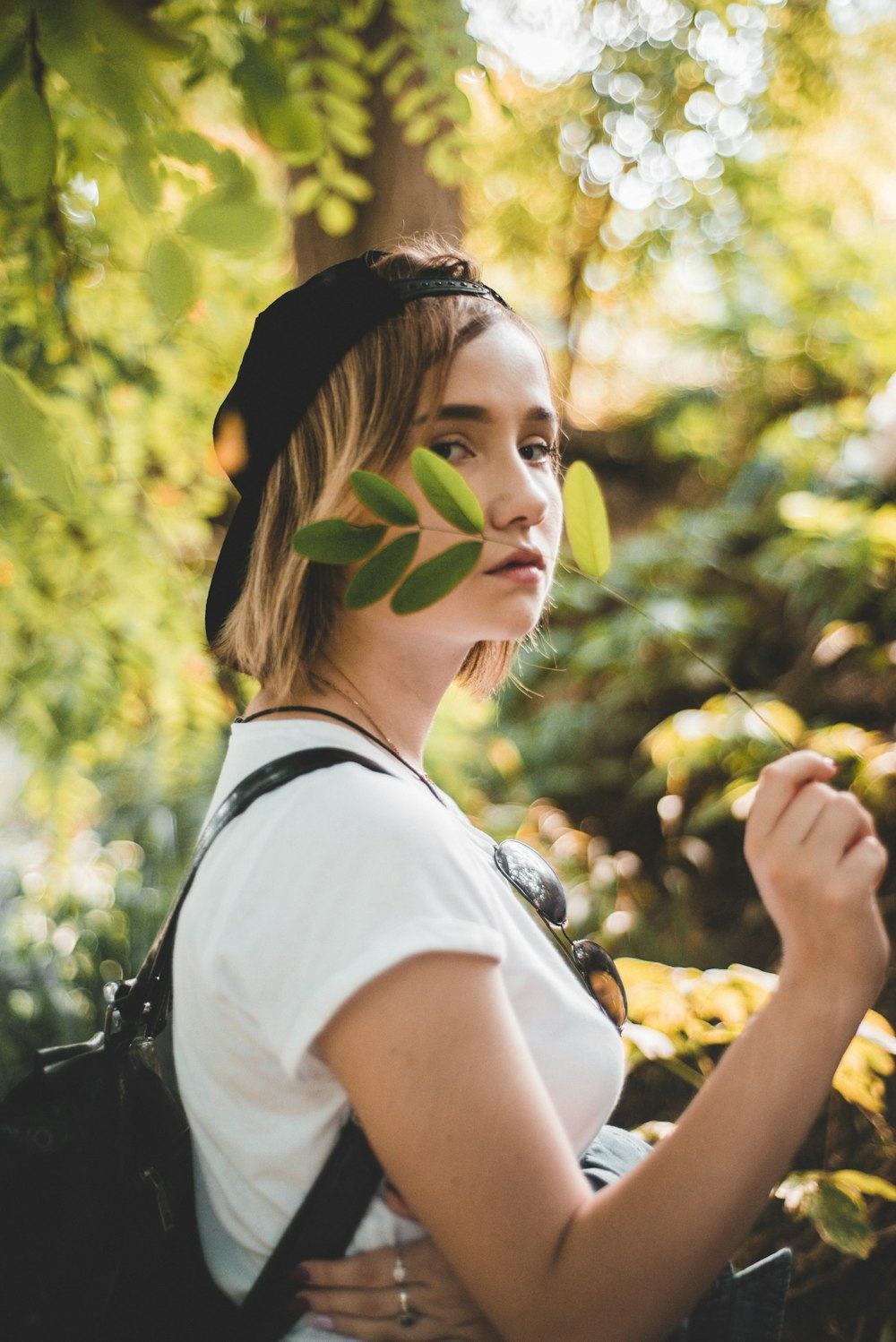 selective-focus photography of woman holding leafed