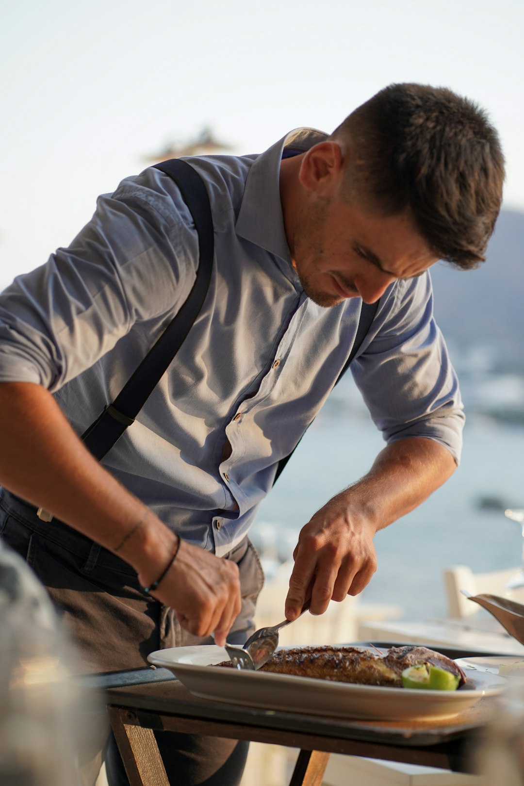 man eating a cooked fish