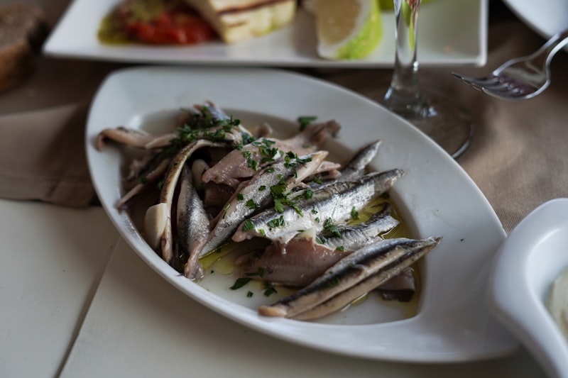 Silver anchovy fillets served on a white plate