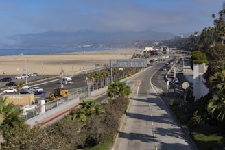A scenic view of a tropical beach with a rental car parked nearby under a clear blue sky.