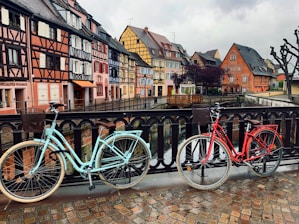 two parked cruiser bikes beside fence