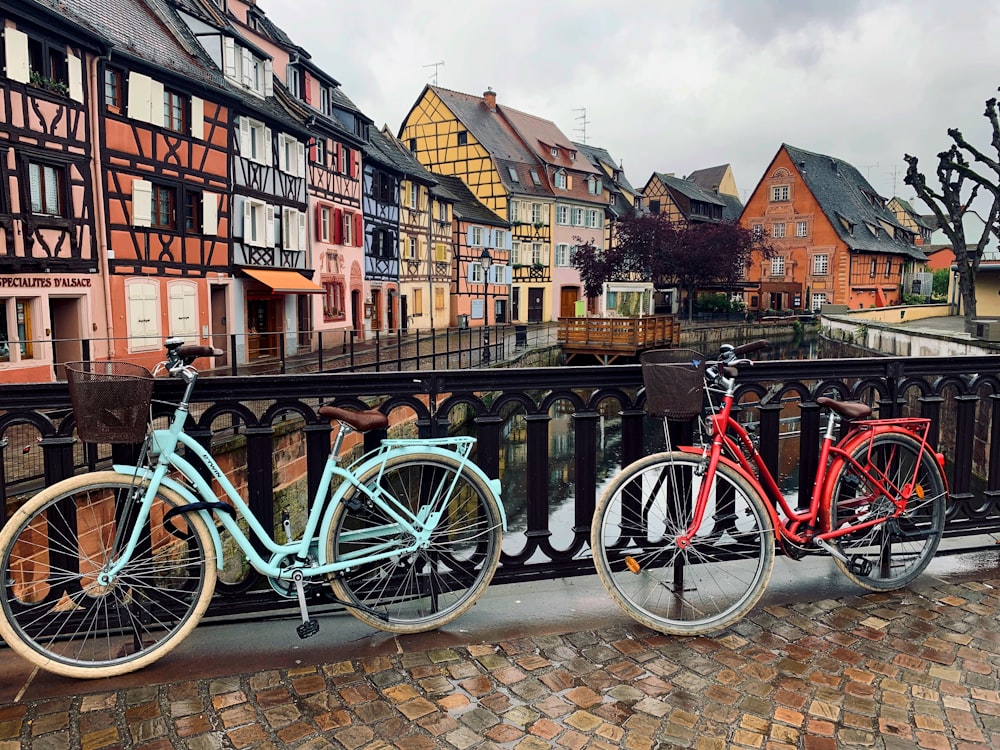 two parked cruiser bikes beside fence