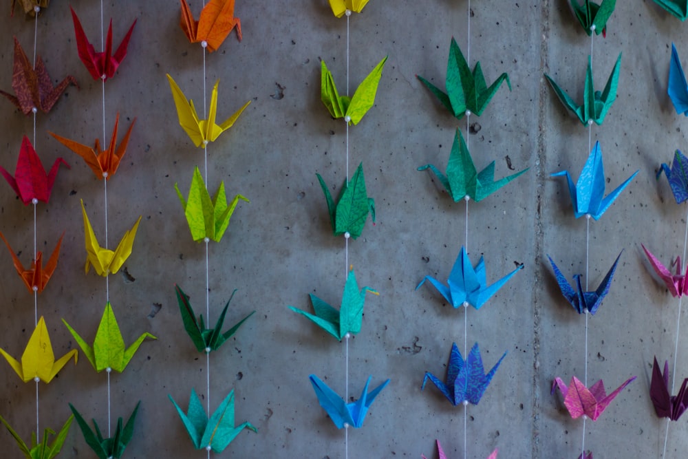 Un gruppo di uccelli origami appesi a un muro