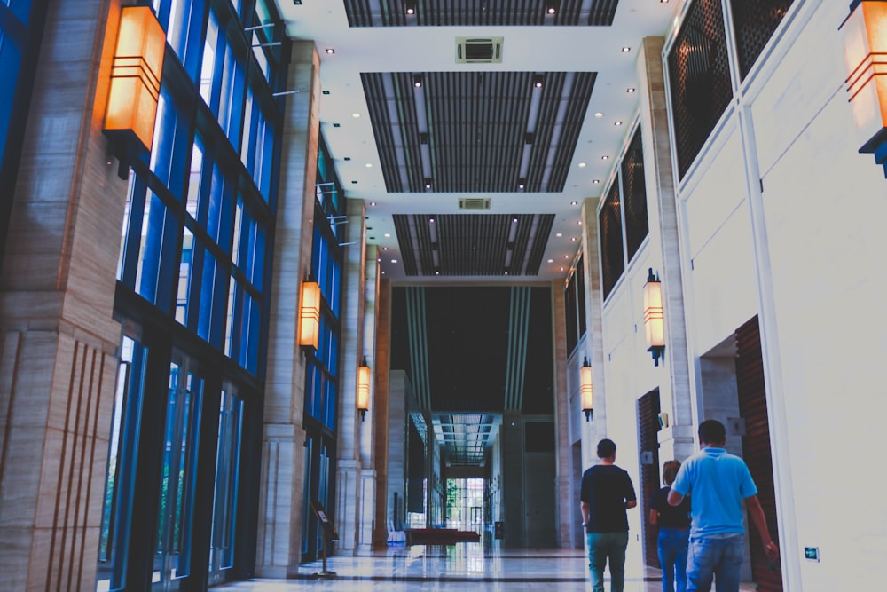 three people walking inside building