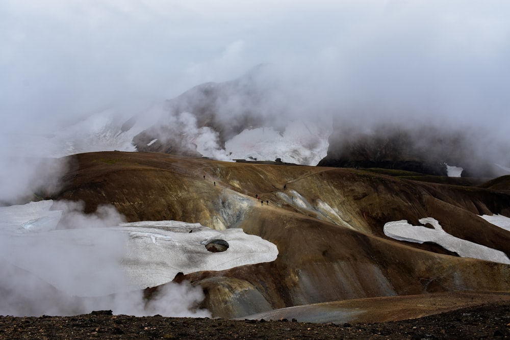 steam rises from the ground near a mountain