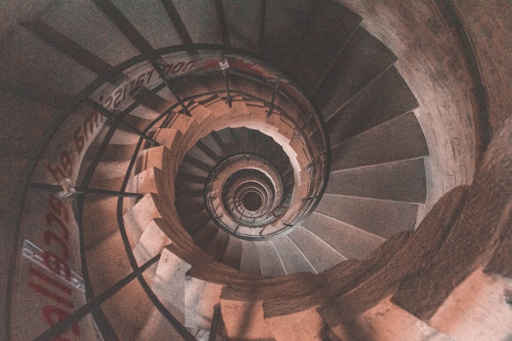 a spiral staircase in a building with graffiti on it