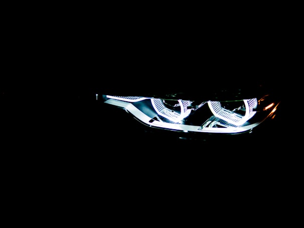 Brightly illuminated LED headlights with a modern, sleek design visible in the darkness, emphasizing a futuristic and high-tech aesthetic.