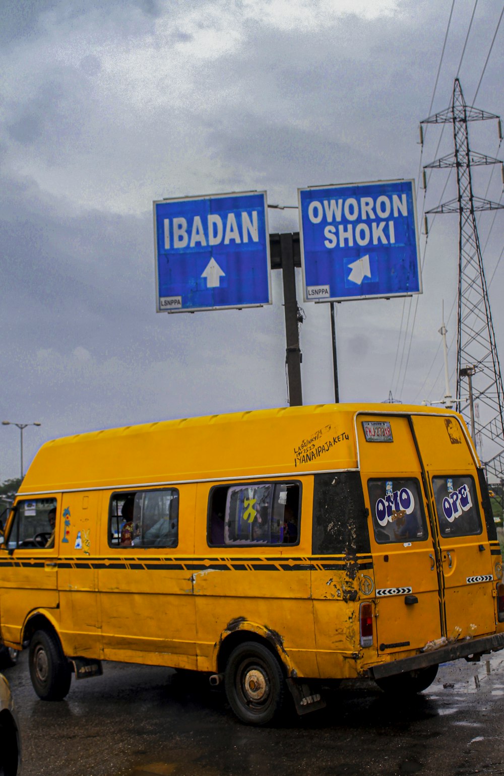 a yellow van driving down a street next to power lines