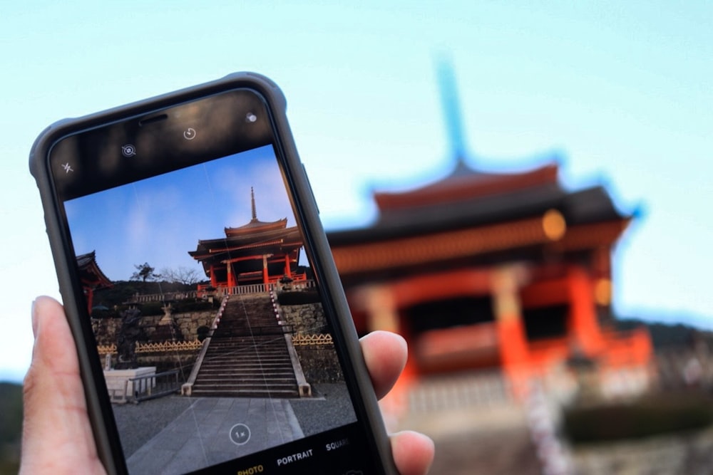 person holding black smartphone displaying Camera application