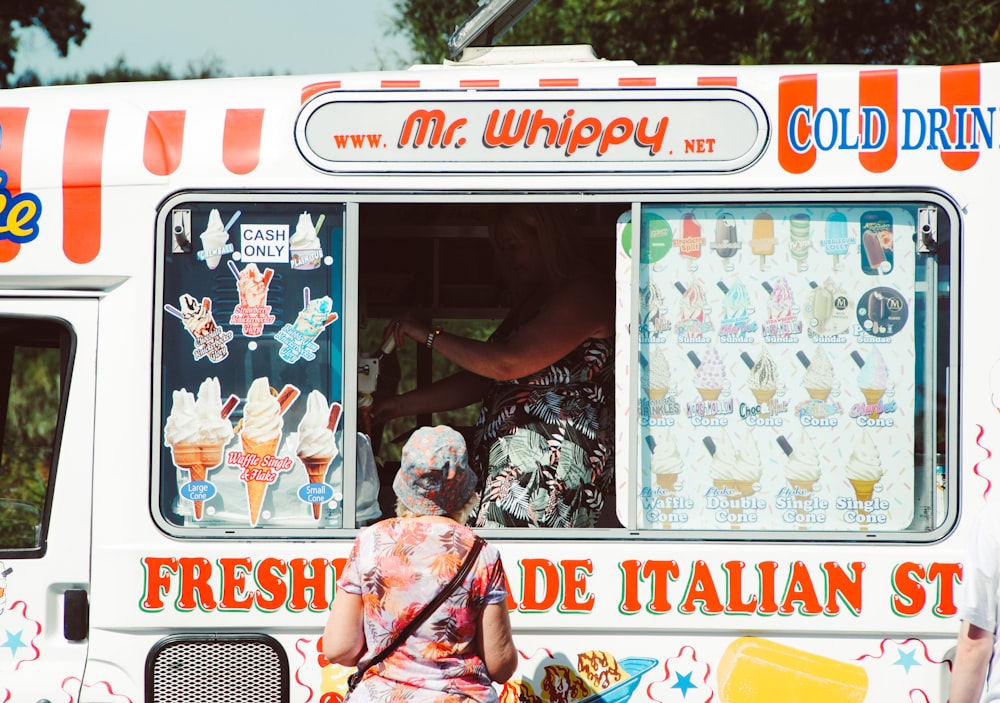 a man and a woman standing in front of a food truck