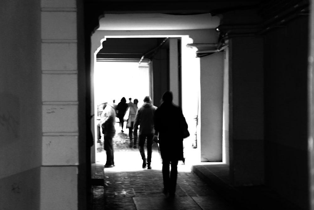 grayscale photography of people walking on hallway