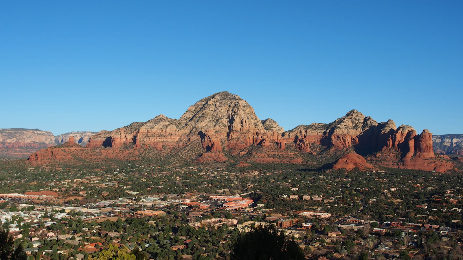Dramatic red rock canyon formations glowing crimson under a clear desert sky in Sedona, Arizona