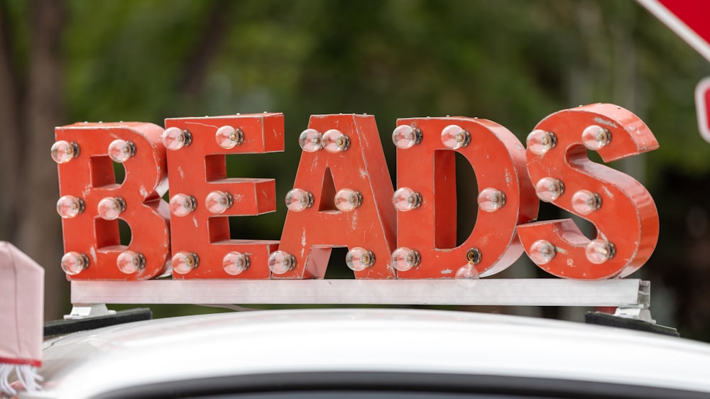 selective focus photography of red BEADS sign