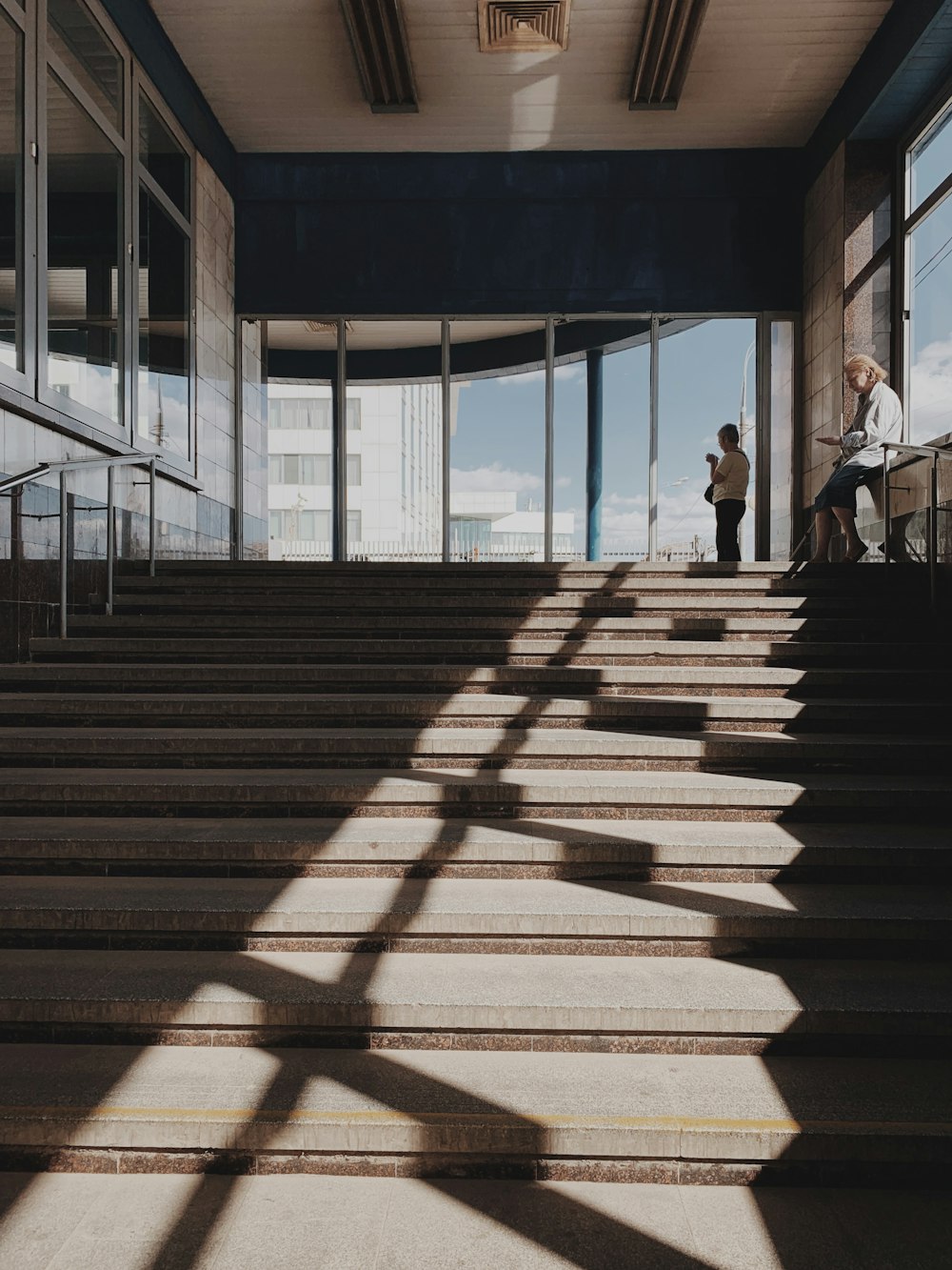 two people standing on top of stairs