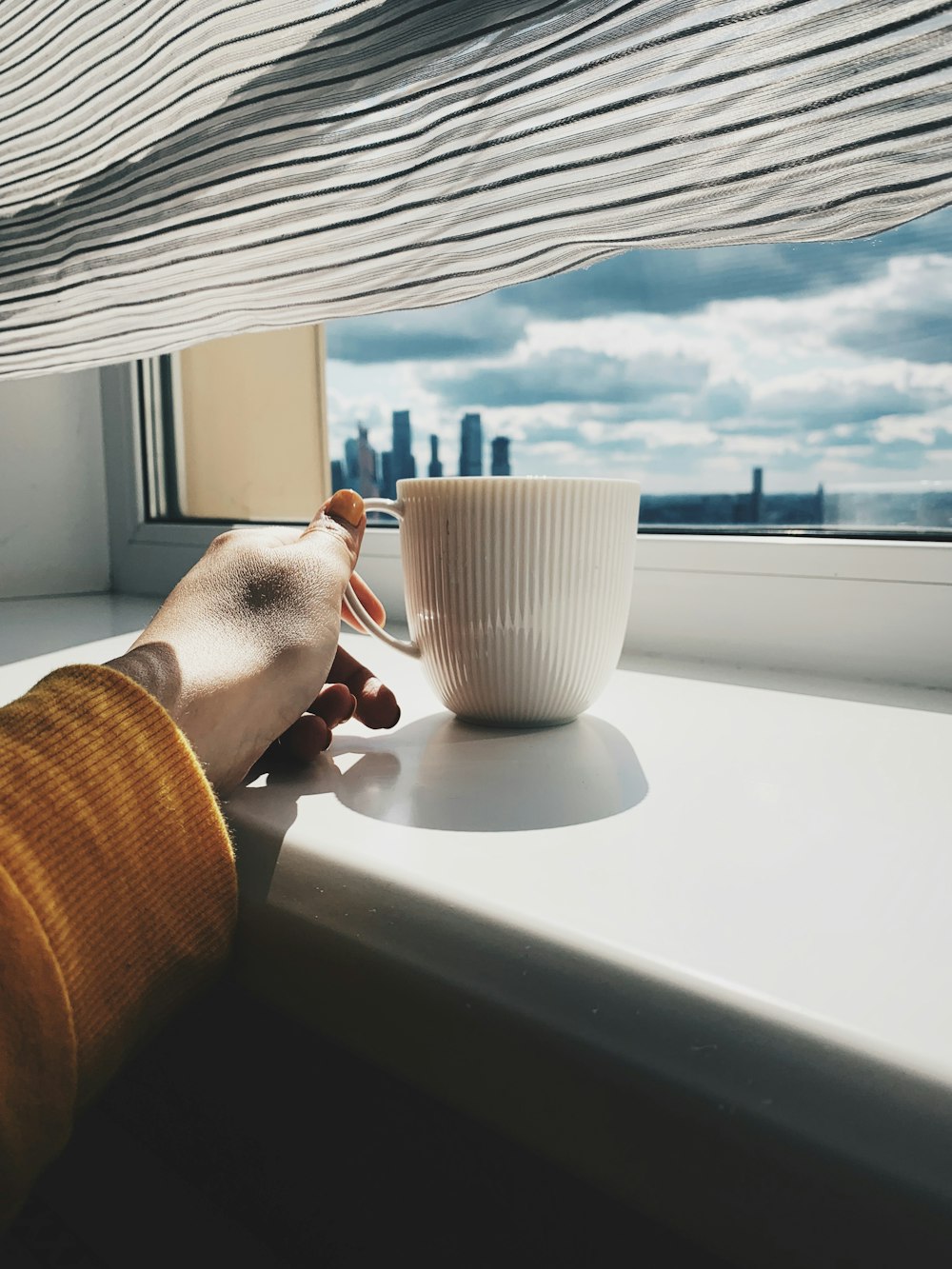 person holding cup on window