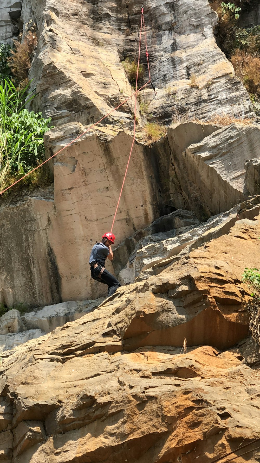 person wearing red helmet hiking during daytime