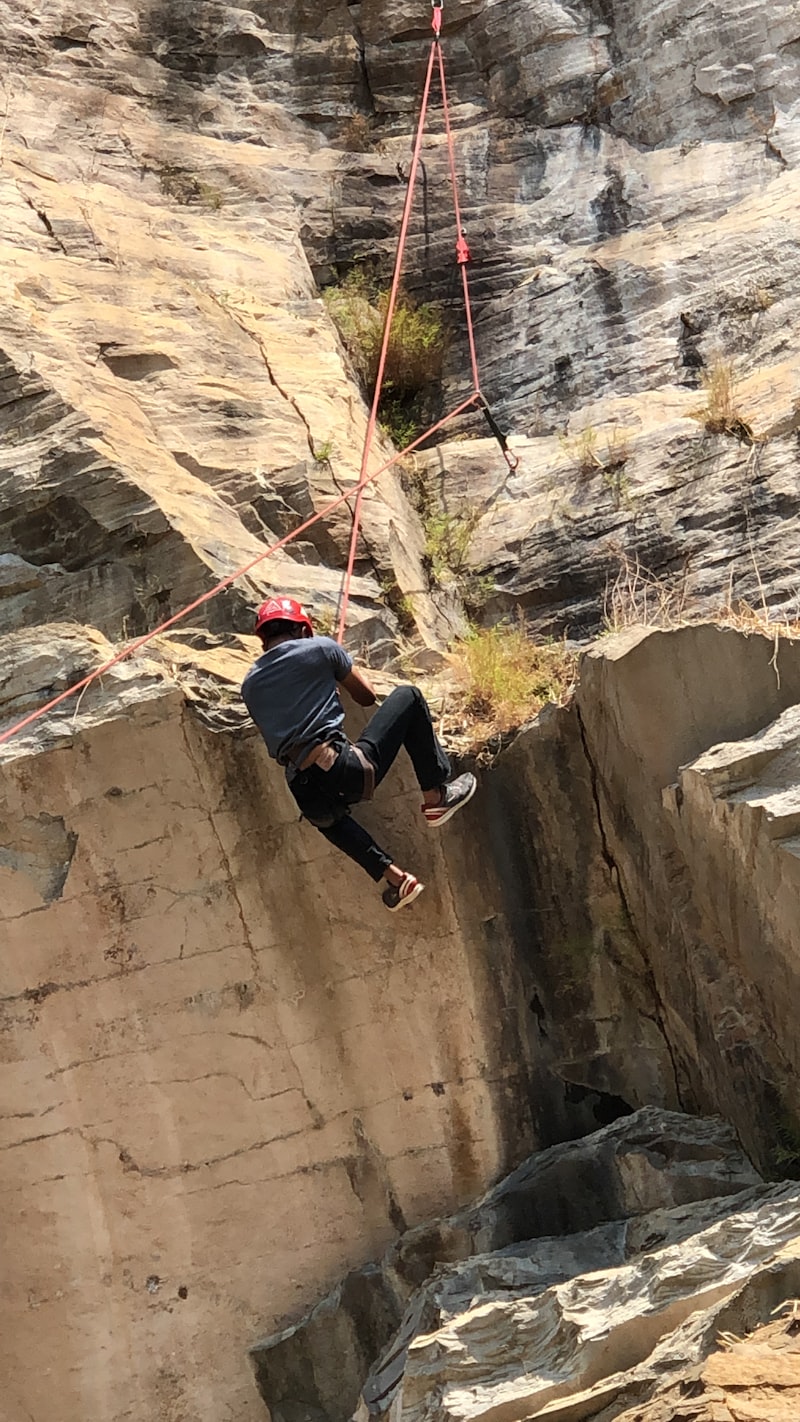 Moniteur d'escalade professionnel en action sur paroi rocheuse