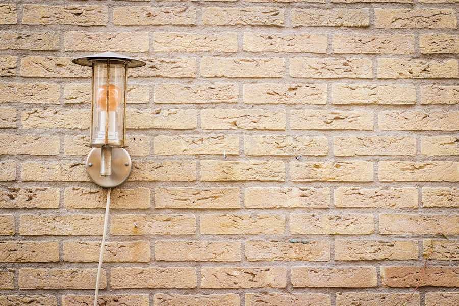 Warm sconce lamp glowing against a textured brick wall