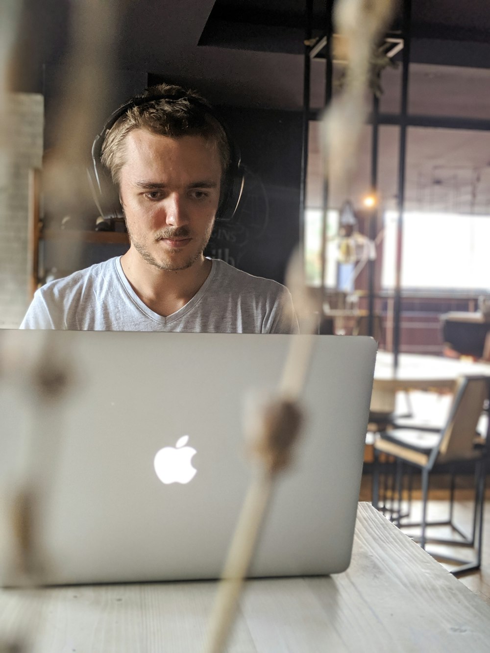 man wearing gray v-neck shirt in front of Apple MacBook