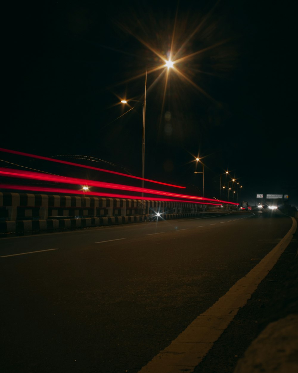 a street at night with a long exposure of lights