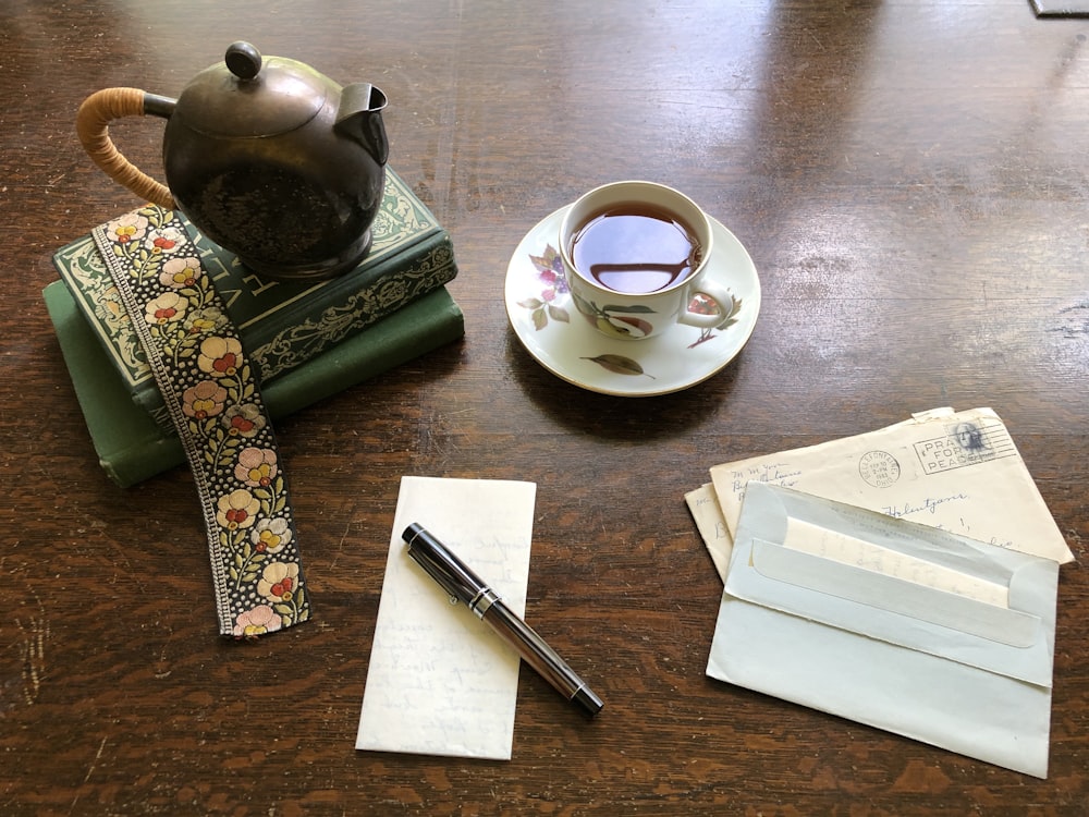 tasse de thé à côté de livres et de lettres