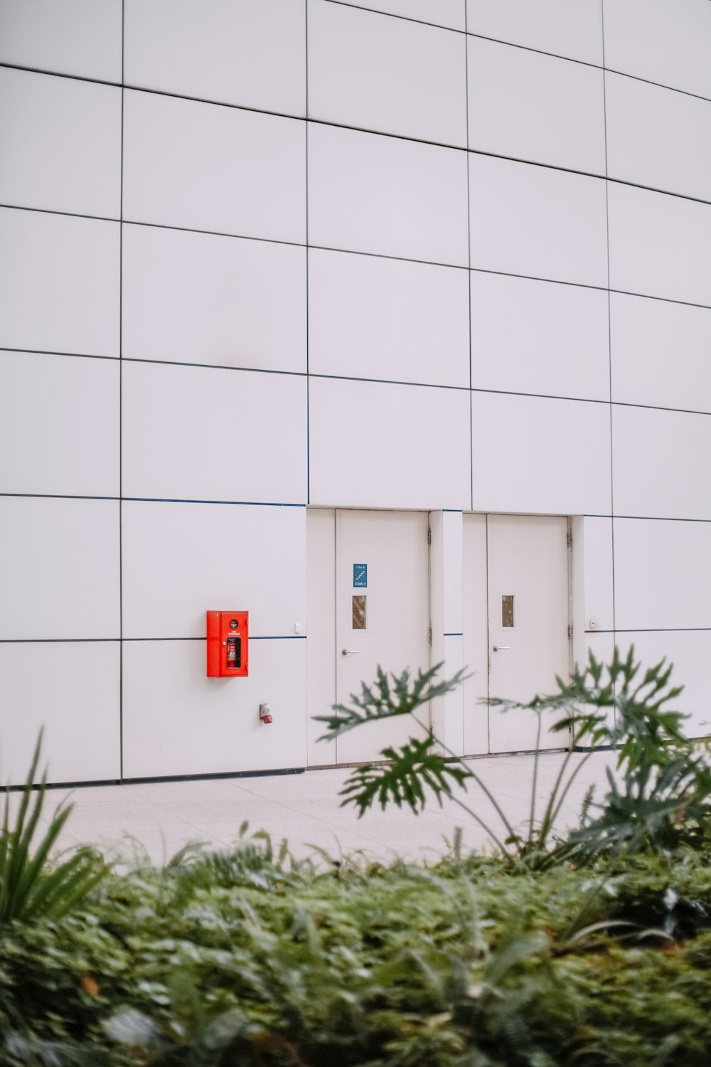 a couple of white doors sitting on the side of a building