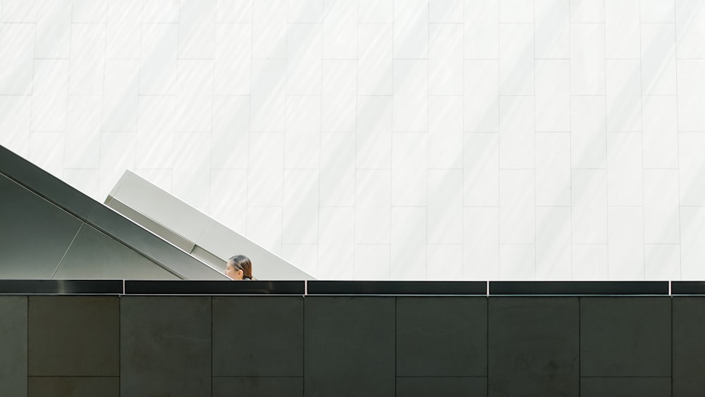 an escalator in front of a white wall
