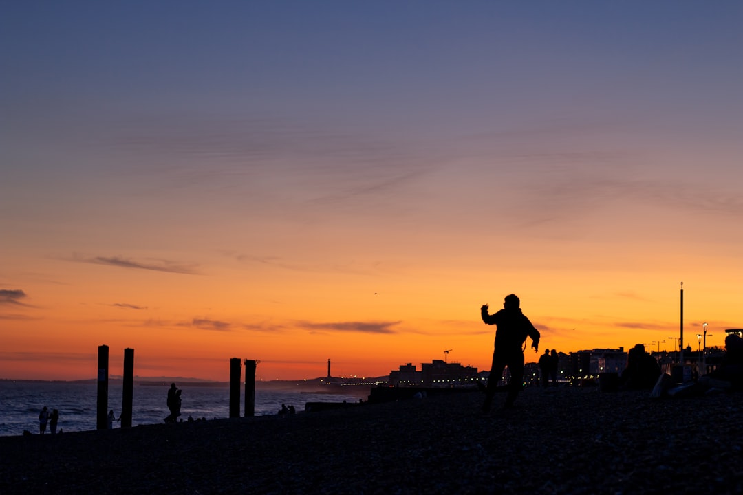 a person standing on a beach at sunset,