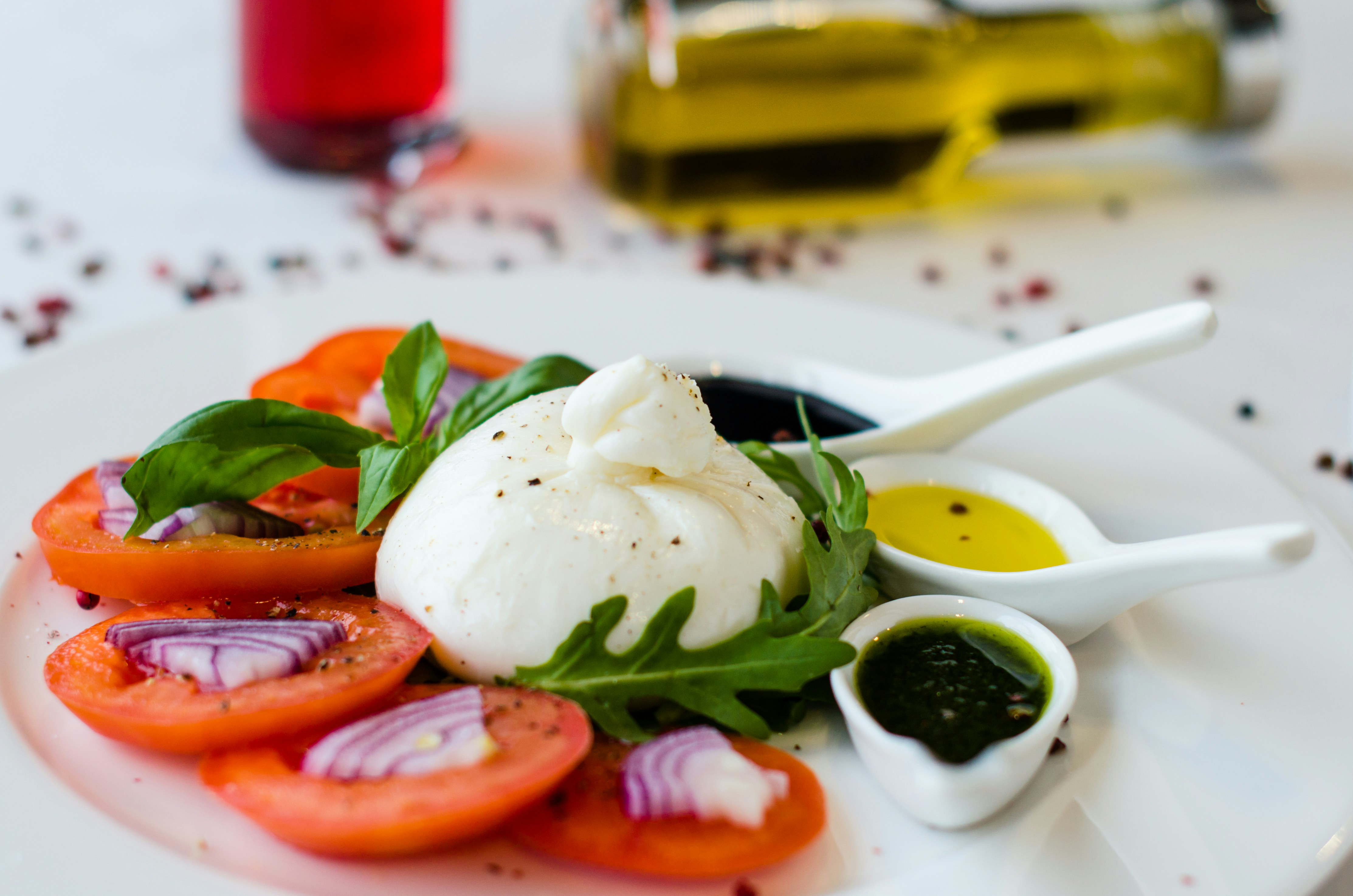 Burrata cheese with tomato slices, basil, olive oil, and balsamic reduction`