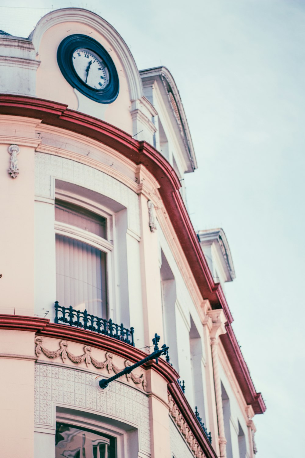 white and red concrete building with clock displaying 12:35