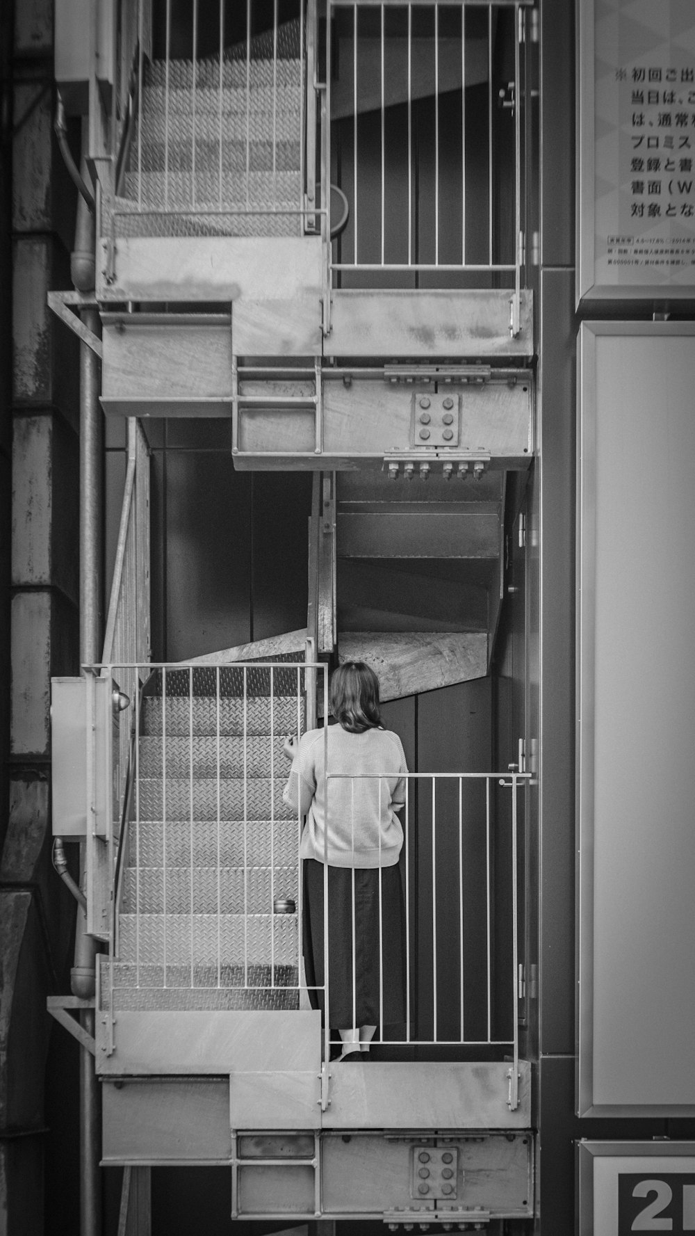 grayscale photo of woman on building