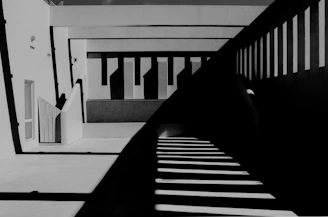 A monochrome architectural detail showcasing sharp angles and deep shadows under soft ambient light.