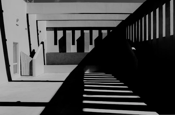 A monochrome architectural detail showcasing sharp angles and deep shadows under soft ambient light.