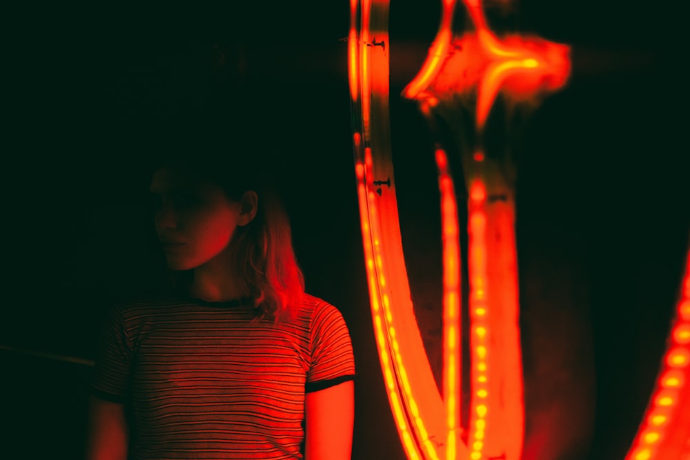 woman standing beside string lights
