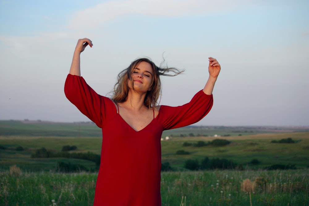 woman standing near grass field at daytime