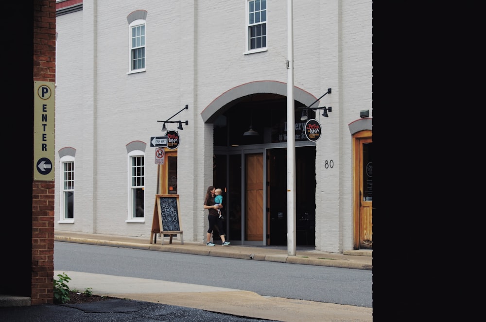 man standing in front of white building