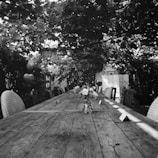 A minimalist linen-draped table set outdoors with soft natural light filtering through trees.