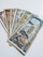 A collection of vintage currency notes fanned out on a flat surface. The notes display a variety of colors, designs, and denominations, suggesting they are from different historical periods or countries.