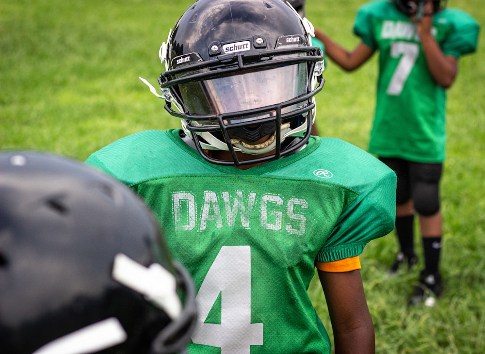 boy wearing green Dawgs 4 jersey wearing black helmet